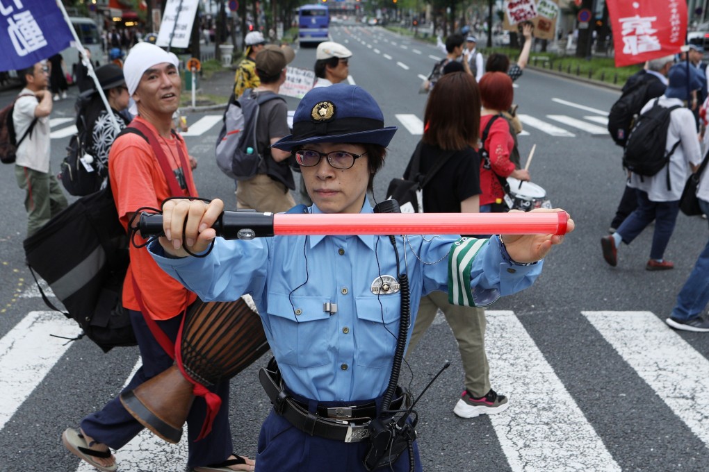 A police officer stops traffic as demonstrators protest at the G20 summit in Osaka. Photo: Bloomberg