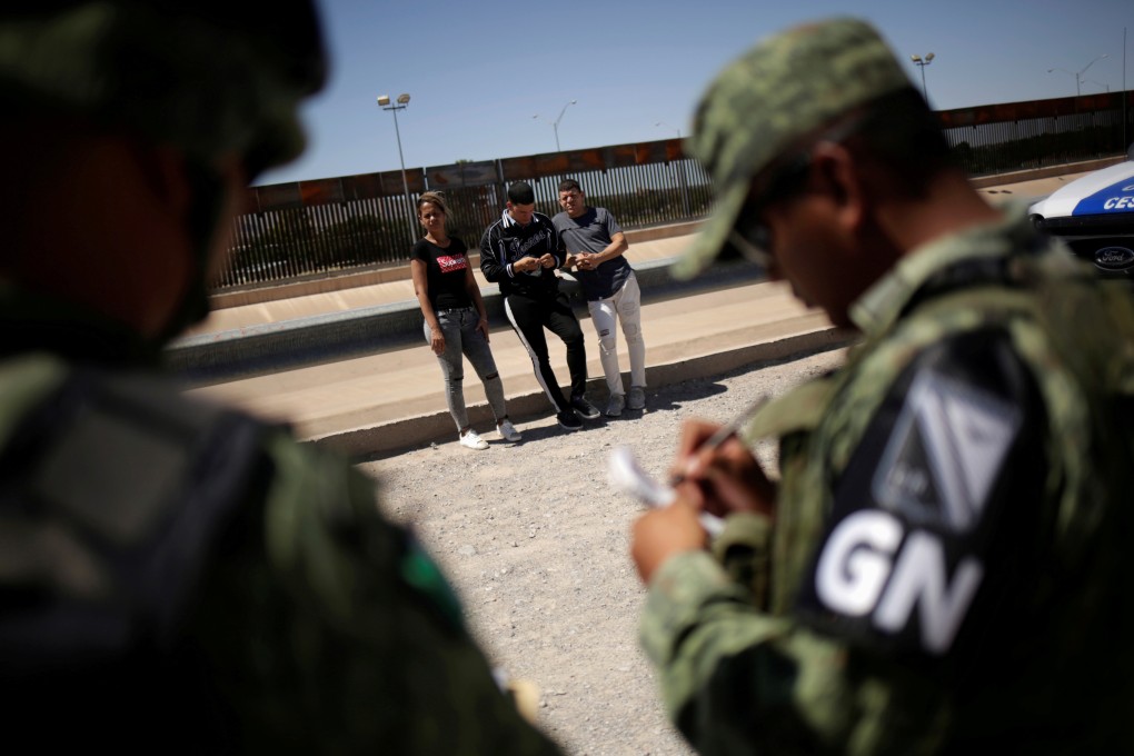 Members of Mexico's National Guard detain Cuban migrants after they tried to cross the border into the US in Ciudad Juarez on Friday. Photo: Reuters