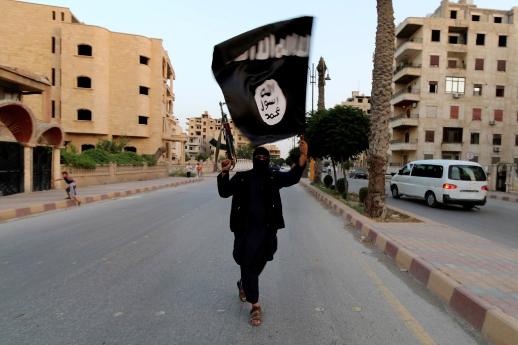 A man loyal to Islamic State waves a flag in Raqqa, Syria, in 2014. Singapore has arrested three people for links to the militant group, according to the island nation’s home ministry. Photo: Reuters