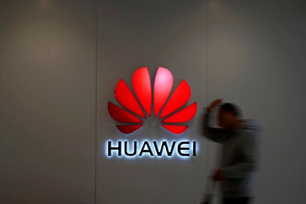 A man walks by a Huawei logo at a shopping centre in Shanghai in December. Photo: Reuters