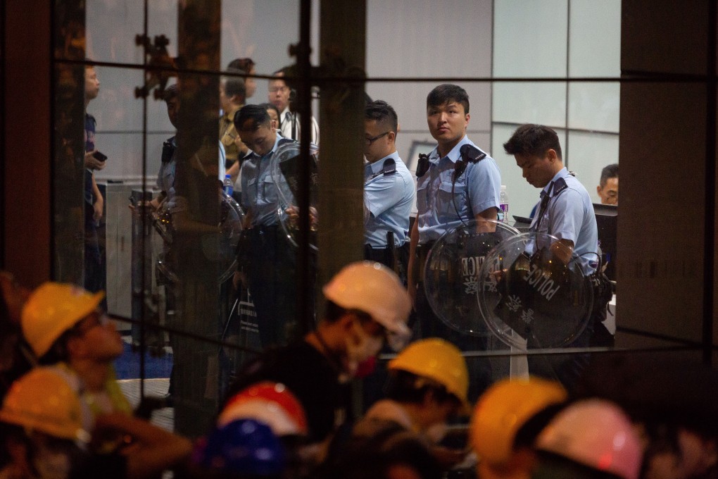 Officers stand inside the police headquarters in Wan Chai after the complex was blockaded by protesters calling for the complete withdrawal of the government’s extradition bill. Photo: Bloomberg