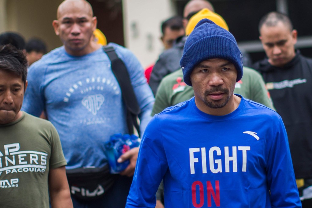 Filipino boxer Manny Pacquiao leaves his house in the morning to jog with fans and friends in Los Angeles, where he is training for his fight against Keith Thurman. Photo: AFP