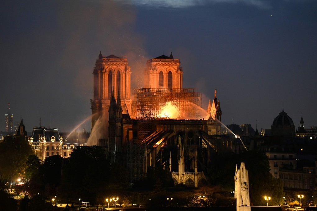 Firefighters douse flames rising from the roof at Notre-Dame Cathedral in Paris. Photo: AFP