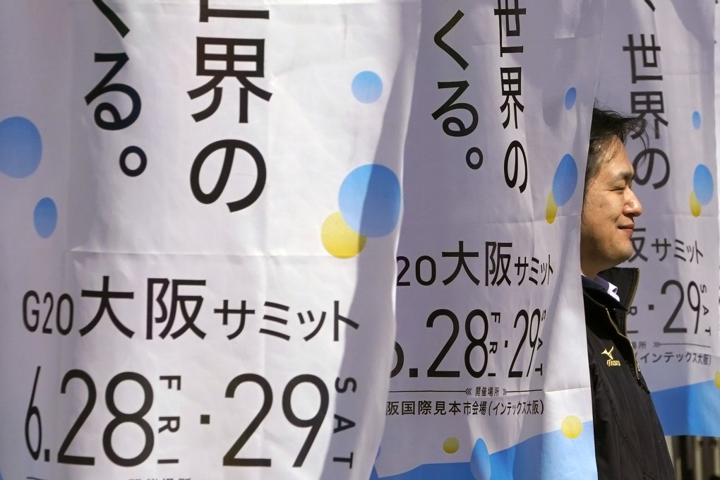 A man walks between advertisements for the G20 summit at the International Exhibition Centre in Osaka, Japan, on May 31. Photo: AP