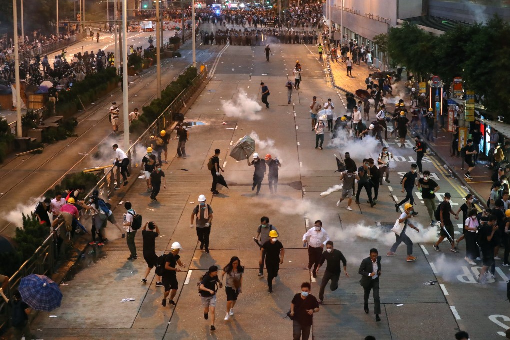 Extradition bill protesters run as police fire tear gas during clashes in Admiralty. Photo: Nora Tam