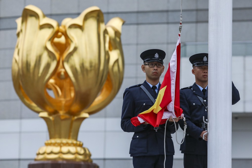 Officers raise the Chinese flag during a ceremony at the Golden Bauhinia Square in Wan Chai. Photo: Robert Ng