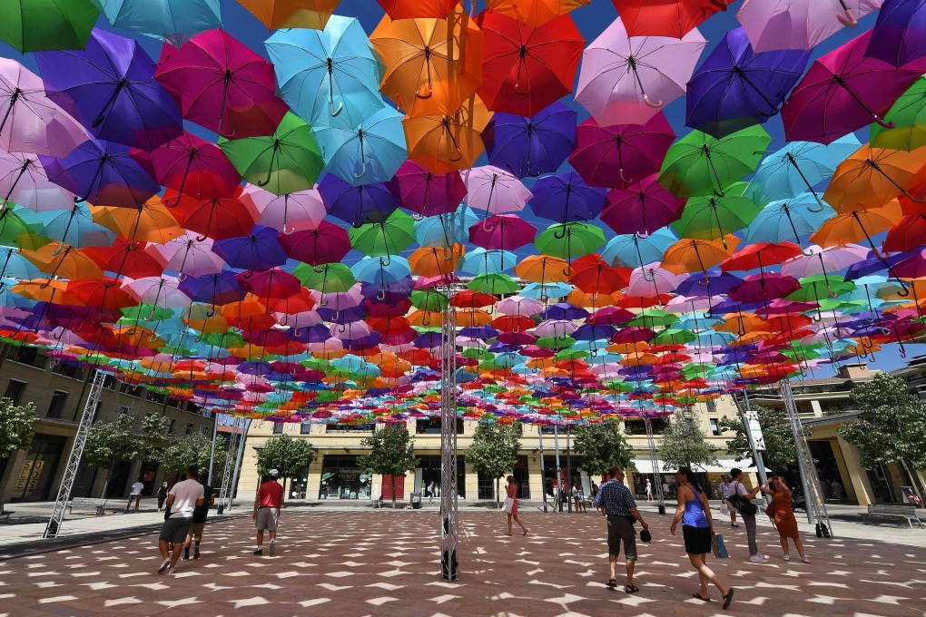 Visitors take shelter from the heat under “Umbrella Sky Project” installation by a Portuguese artist in Aix-en-Provence, France. Photo: AFP