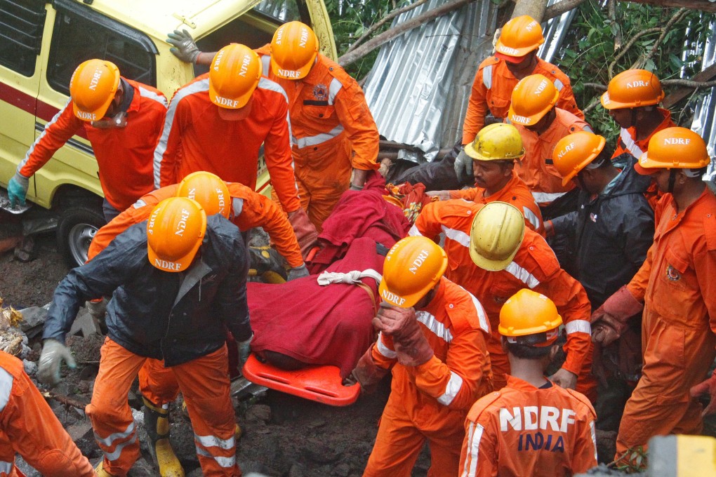 Rescuers carry the body of a victim of the wall collapse in Pune on Saturday. Photo: Reuters
