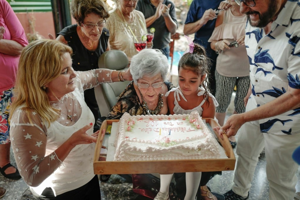 Delia Barroso, 102, blows out the candles on her birthday cake at a party in Havana. Photo: AFP