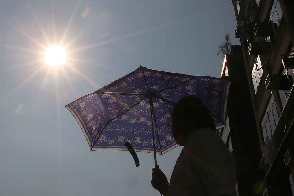 A woman seeks protection from the sun in Tuen Mun. There were nine days with an average temperature above 33 degrees in 1976 – there were 38 in 2016. Photo: K.Y. Cheng
