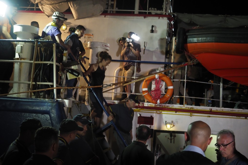 Sea-Watch 3 captain Carola Rackete (C) being arrested after entering the port of Lampedusa and ramming a patrol boat. Photo: EPA-EFE