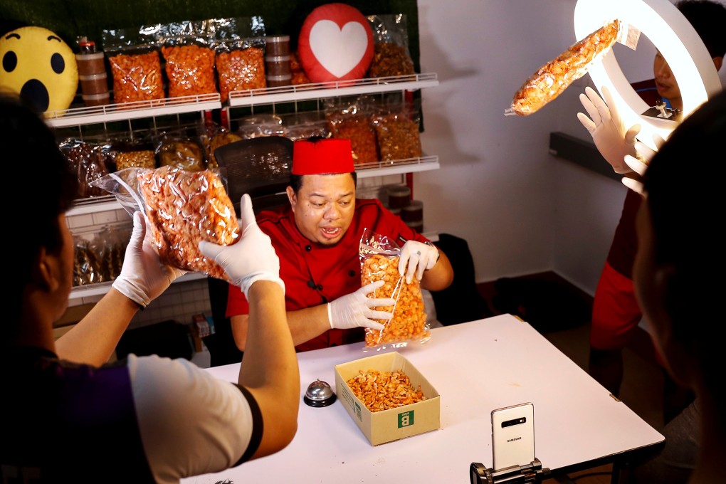 Anurak Sareuthai sells dried seafood products with his colleagues during a Facebook live event. Photo: Reuters