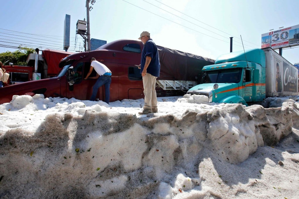 Trucks buried in the hail on Sunday. Photo: AFP