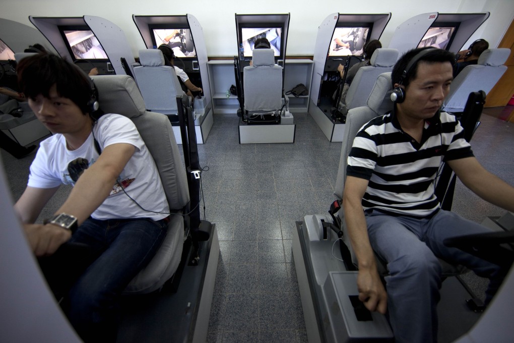People learn basic driving skills on simulators in Beijing, China. Photo: AP