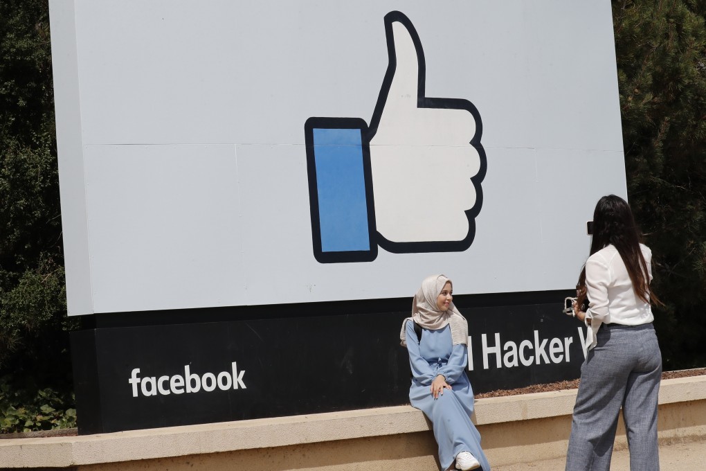 A Facebook fan poses in front of a sign outside Facebook’s headquarters in Menlo Park, California on Monday. Photo: EPA