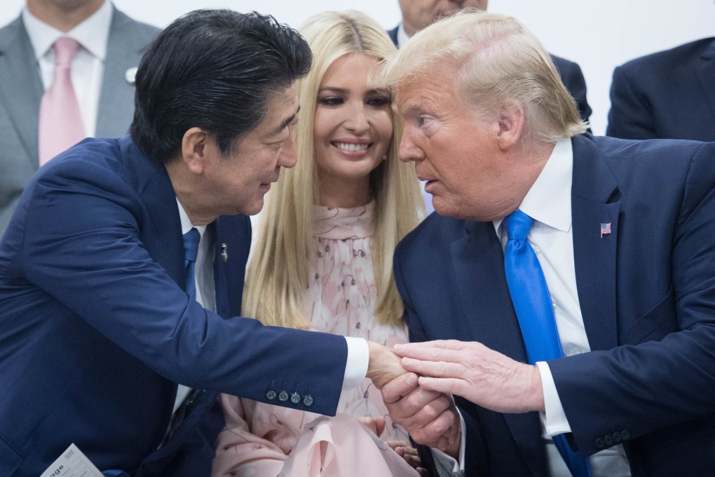 Japanese Prime Minister Shinzo Abe shakes hands with US President Donald Trump as his daughter Ivanka Trump looks on during the an event at the G20 summit on Saturday. Photo: dpa