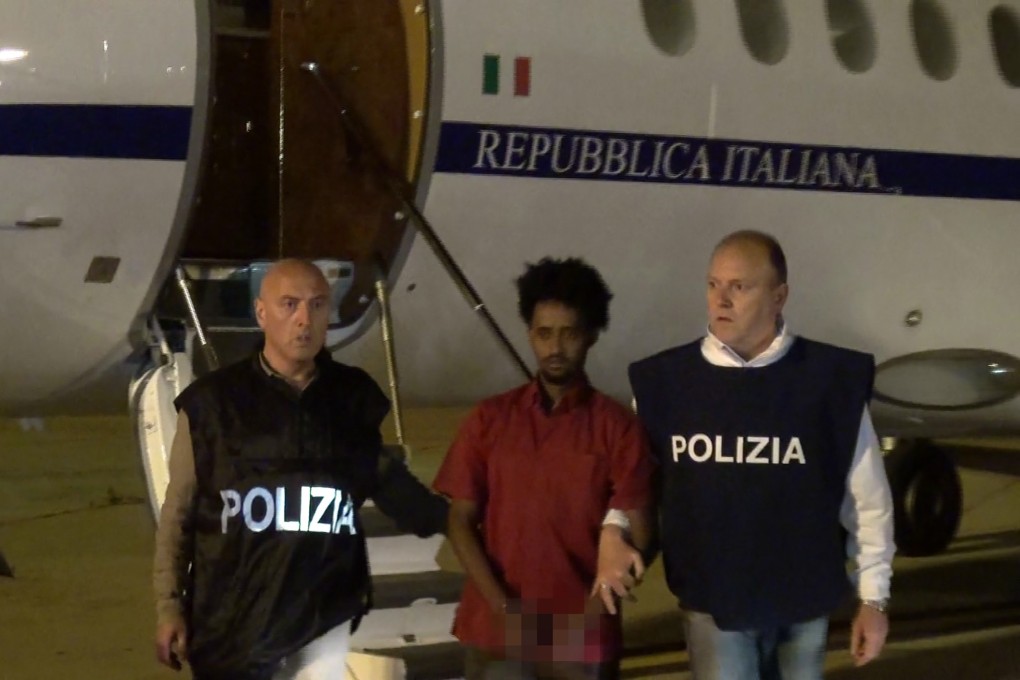 A man prosecutors claim is Medhanie Yehdego Mered, an Eritrean suspected of controlling a human trafficking network, escorted by policemen upon his extradition from Sudan in June 2016. Photo: AFP/Polizia di Stato