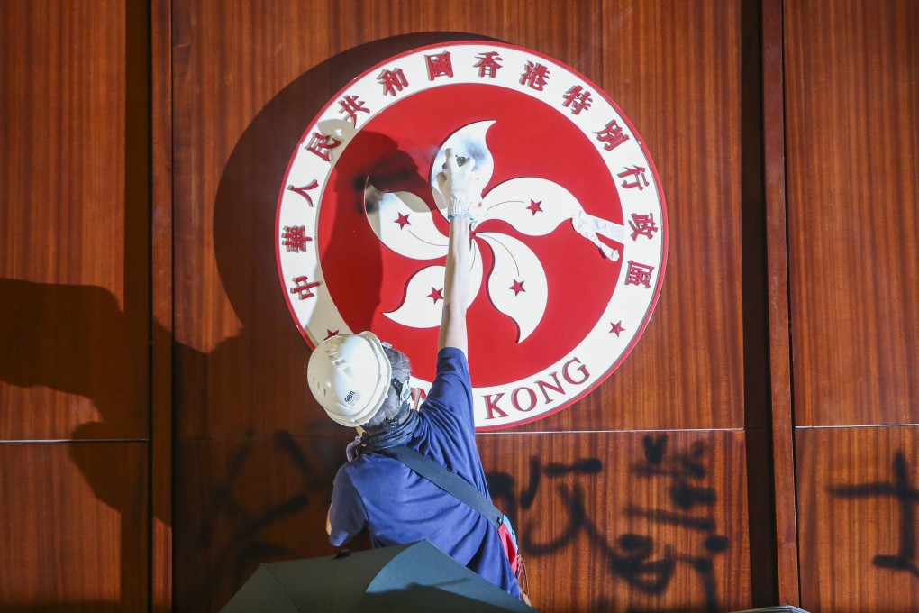 A protester defaces the Hong Kong emblem in the Legislative Council chamber. Photo: Winson Wong