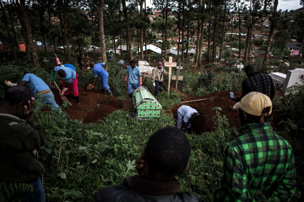 Family members react as they watch a victim of the Ebola virus being buried in Butembo. Photo: TNS