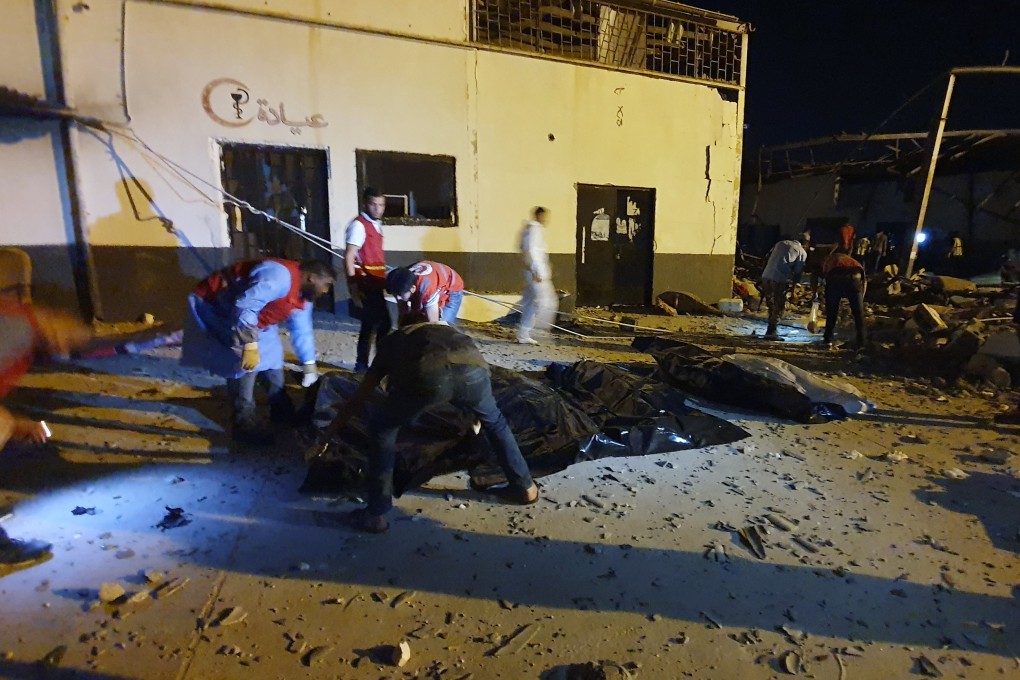 Emergency workers recover bodies after an air strike at Tajoura detention centre, east of Tripoli. Photo: AFP