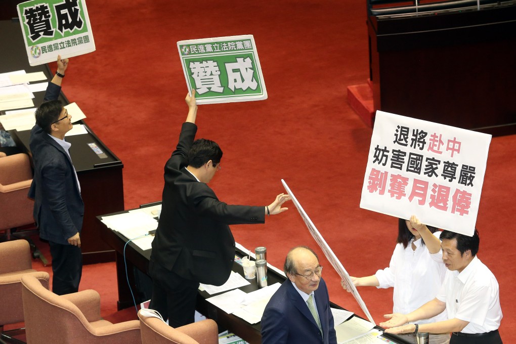 DPP lawmakers hold up placards showing their support for the bill in Taiwan’s legislature on Wednesday. Photo: CNA