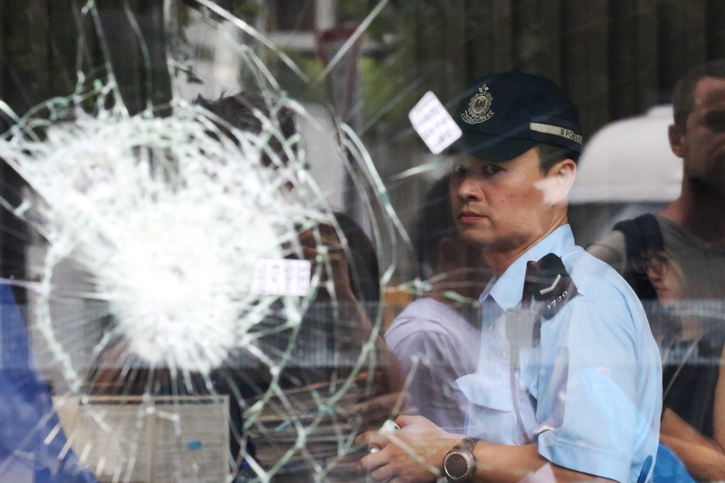 A police officer is seen behind broken glass panels at the Legislative Council building on July 2. Photo: EPA-EFE