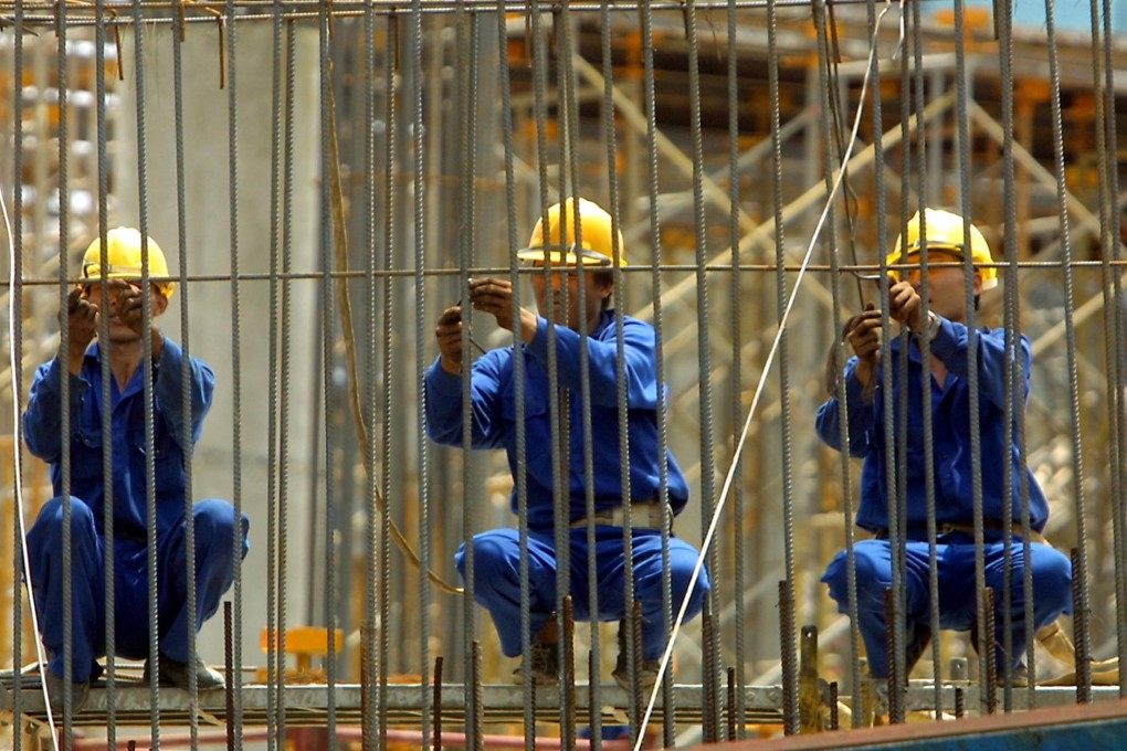 Workers tie up steel rods at a construction site in Hanoi. Photo: AFP