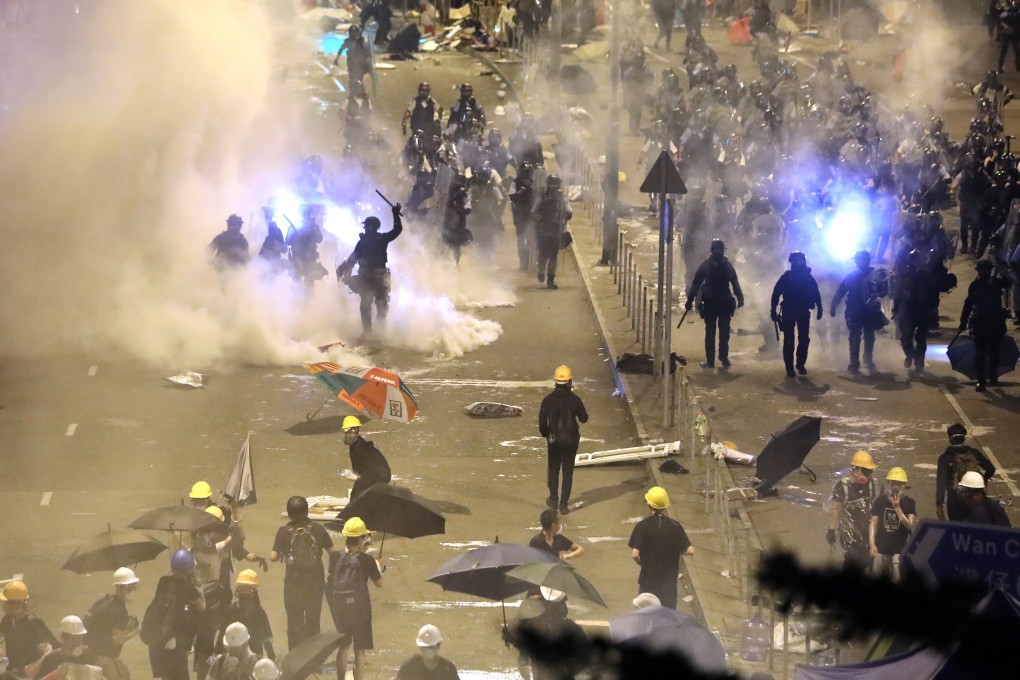 Hong Kong riot police clear the area around government headquarters after protesters stormed the Legislative Council Chamber. Photo: Sam Tsang