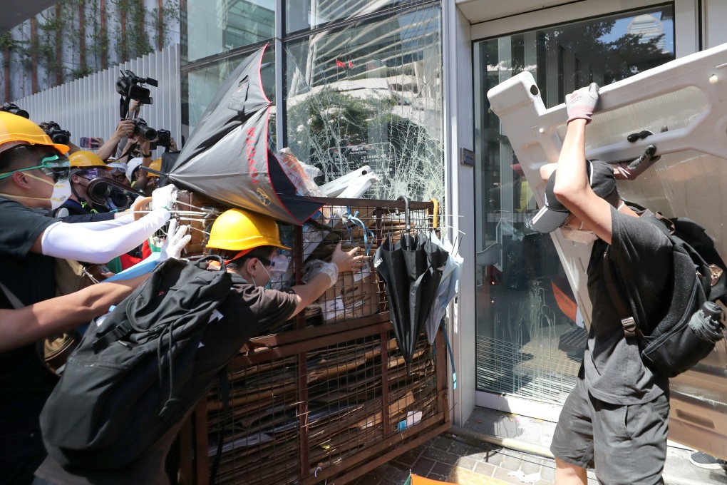 Protesters smash glass panels of the Legislative Council Complex in Tamar during a protest against the extradition bill on the 22nd anniversary of Hong Kong’s handover from Britain to China. Photo: Sam Tsang