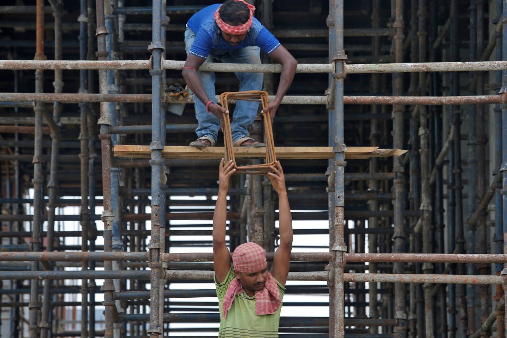 Labourers work at the construction site of a residential building on the outskirts of Kolkata, India. Photo: Reuters
