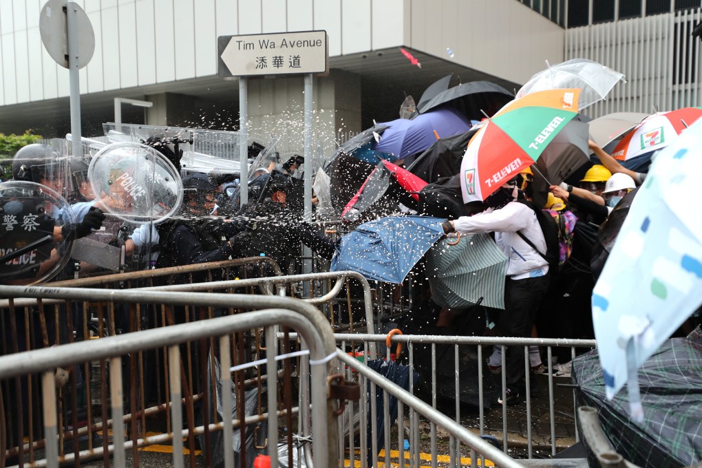 Police officers use pepper spray to drive back protesters on Tim Wa Avenue in Admiralty on June 12. Photo: Sam Tsang