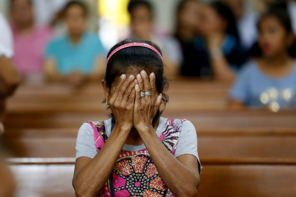 Relative of a victim in President Rodrigo Duterte's so-called war on drugs reacts during a church service in Manila. Photo: AP
