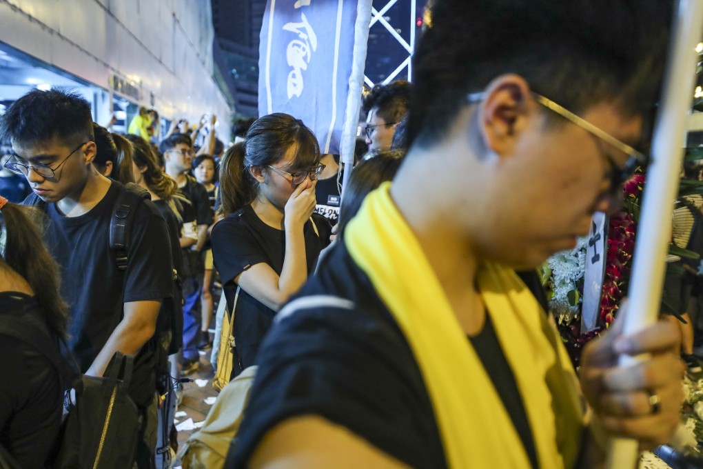 Protesters lay bouquets and offer prayers for a man who fell from Pacific Place mall in Admiralty and died while protesting against Hong Kong’s extradition law last month. Photo: Sam Tsang