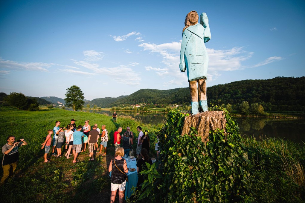 People gather around a statue of Melania Trump near Sevnica, Sloveniat, during a small inauguration celebration on Friday. Photo: AFP