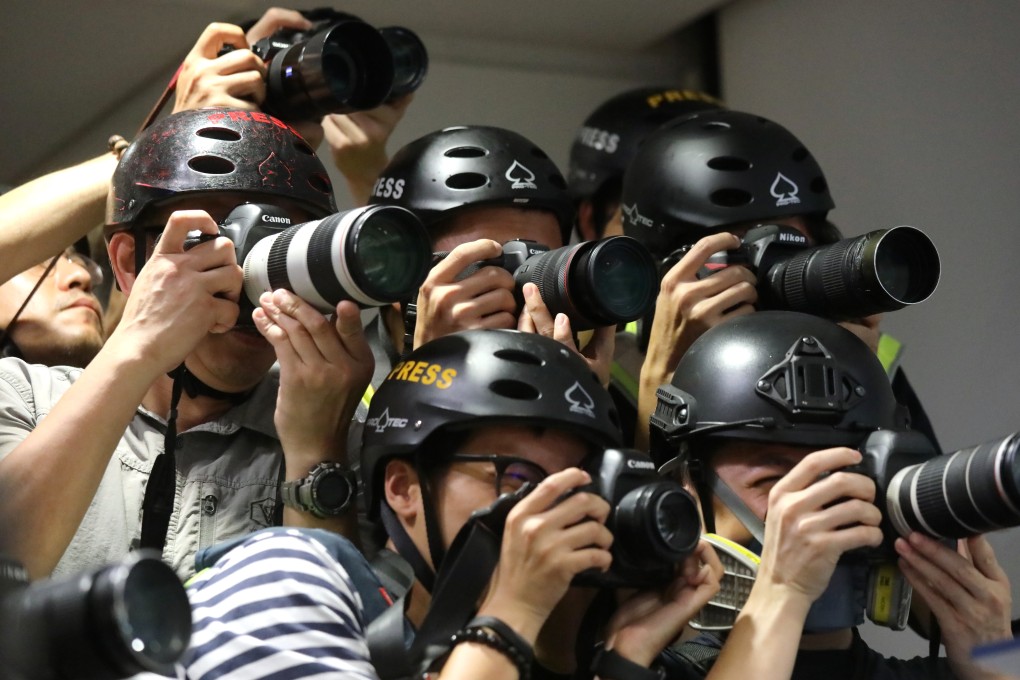 Photographers wear helmets at a police press conference on June 13, in protest against the force’s handling of the media during clashes the night before. Photo: K.Y. Cheng