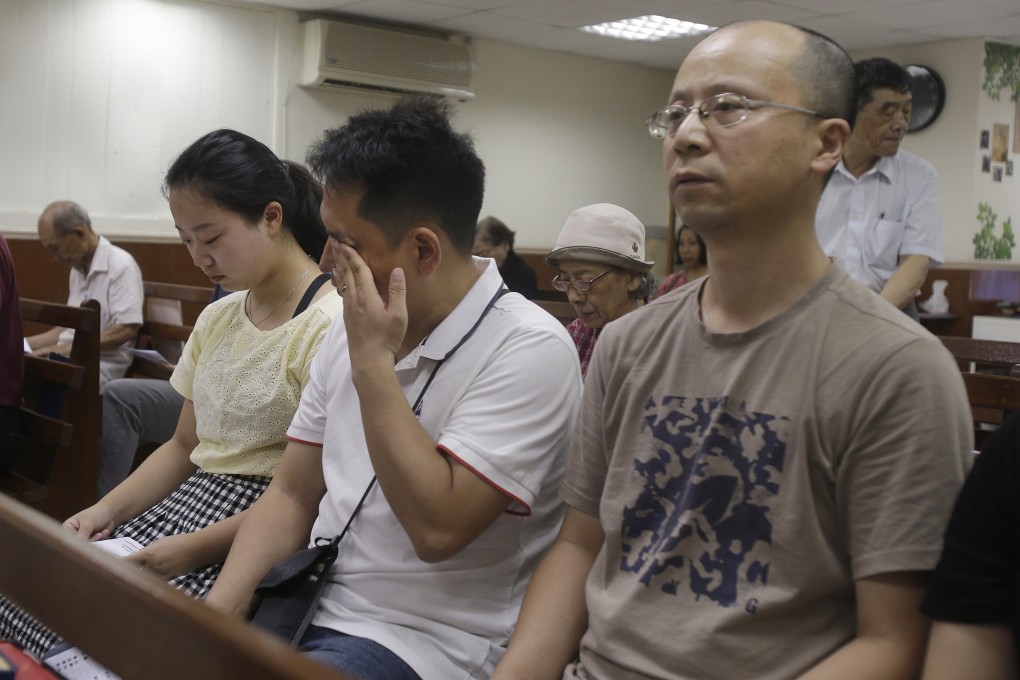 Liao Qiang (right) with members of his family during a service on Sunday at a church in Taipei, Taiwan. Photo: AP