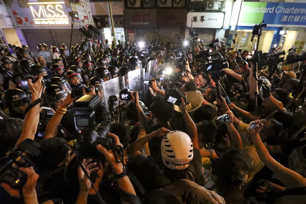 Riot police facing a media crowd as they clear Nathan Road during Sunday’s protests. Photo: Felix Wong