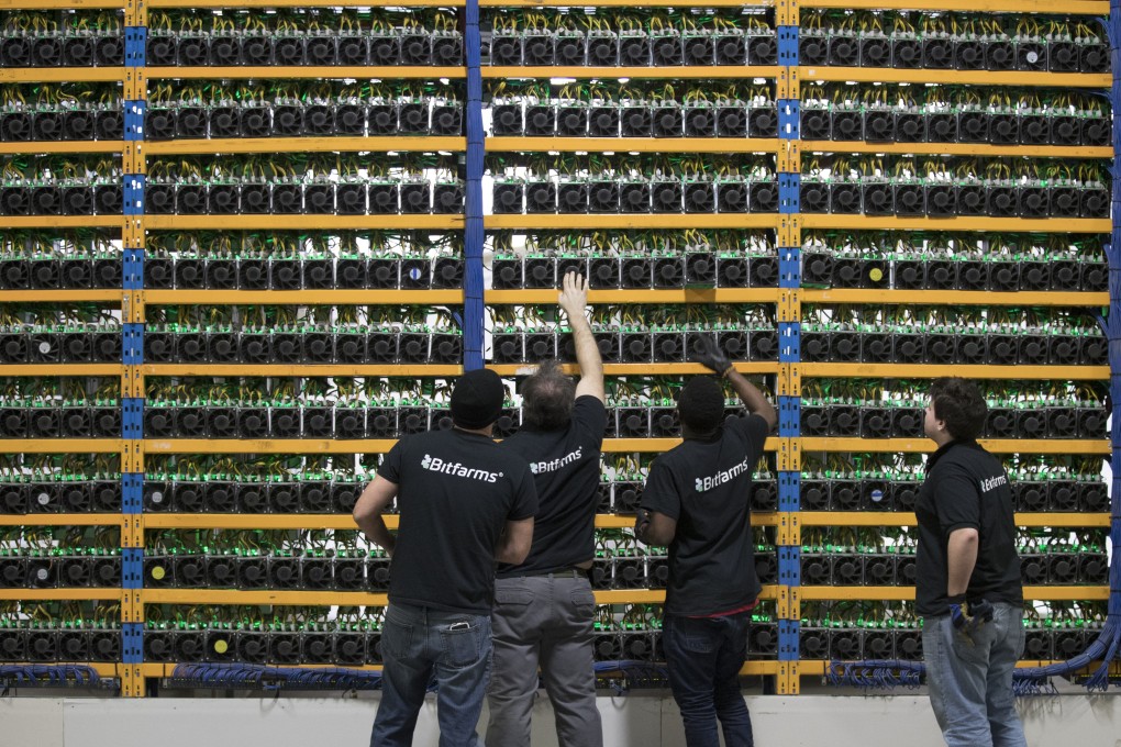 Employees check fans on mining machines at the Bitfarms cryptocurrency farming facility in Farnham, Quebec, Canada. Photo: Bloomberg