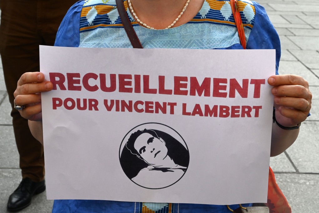 A woman holds a sign reading ‘meditation for Vincent Lambert’ during a vigile in front of the Saint-Sulpice church in Paris on July 10. Photo: AFP