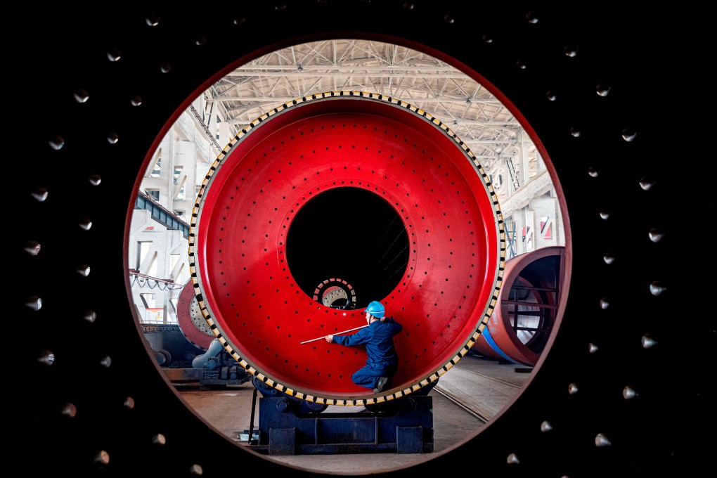 A worker measures a newly manufactured ball mill machine at a factory in Nantong, Jiangsu province. A recent survey found that, despite the trade war, around 60 per cent of US companies were not even considering relocating manufacturing from China to other countries. Photo: Reuters