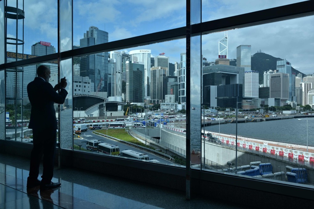 A guest takes a photo of Hong Kong’s skyline as protesters gathered near the waterfront on July 1. The city has recently taken a reputational hit, as it has done several times in the past and recovered each time. Photo: AFP