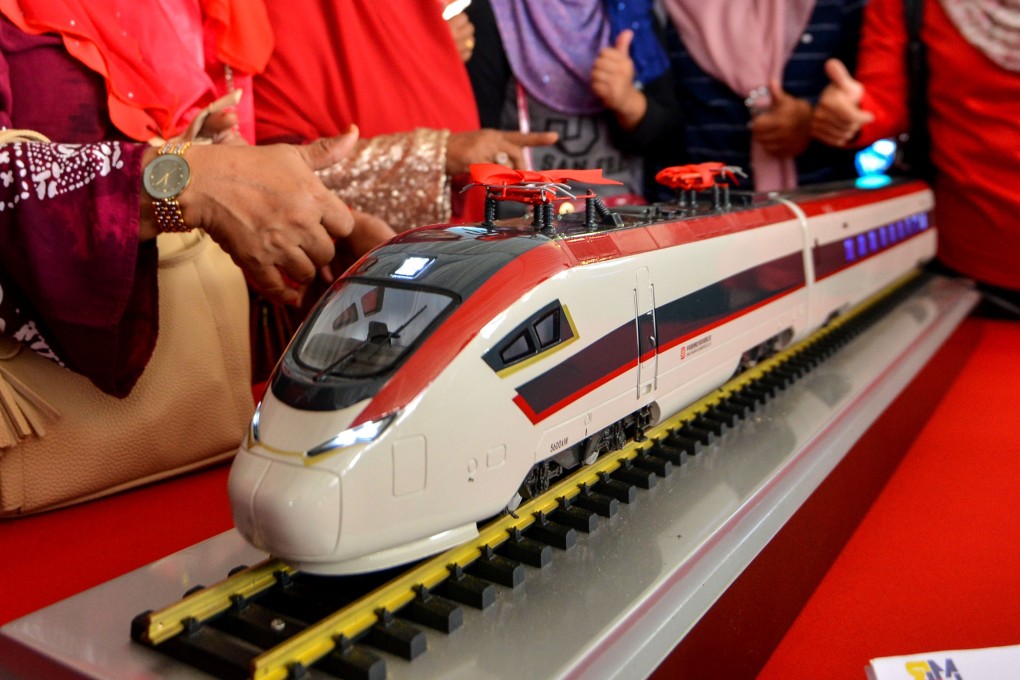 People pose with a model of a train during the ground breaking ceremony for the ECRL in 2017. Photo: Xinhua