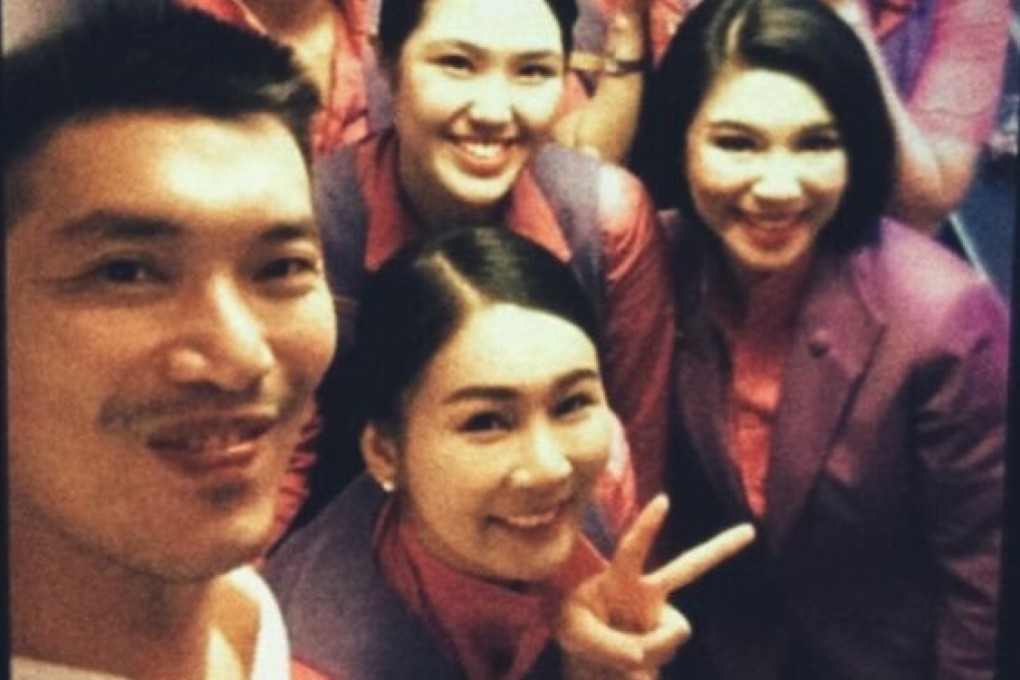 Thai Airways cabin crew selfie with Thanathorn Juangroongruangkit. Photo: Twitter / @yuhtlerd