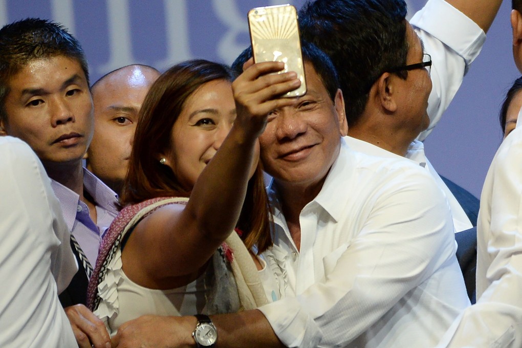 A supporter takes a selfie with Philippine President Rodrigo Duterte. Internet speeds in the country lag the region’s. Photo: AFP
