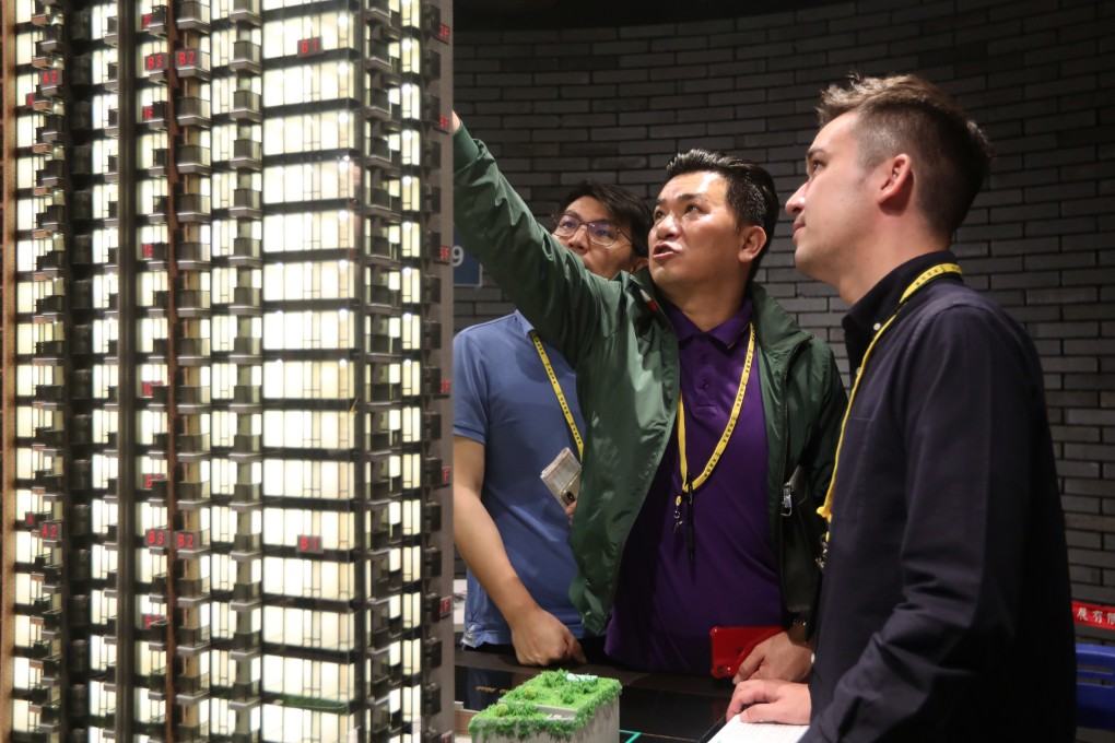 Potential buyers look at a model of New World Development’s Atrium House in Tsuen Wan on June 22. Photo: Xiaomei Chen