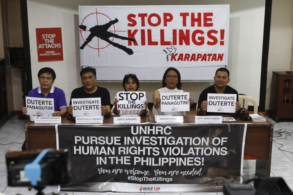 Philippine activists hold signs in support of a UN investigation into the country’s drugs war. Photo: EPA