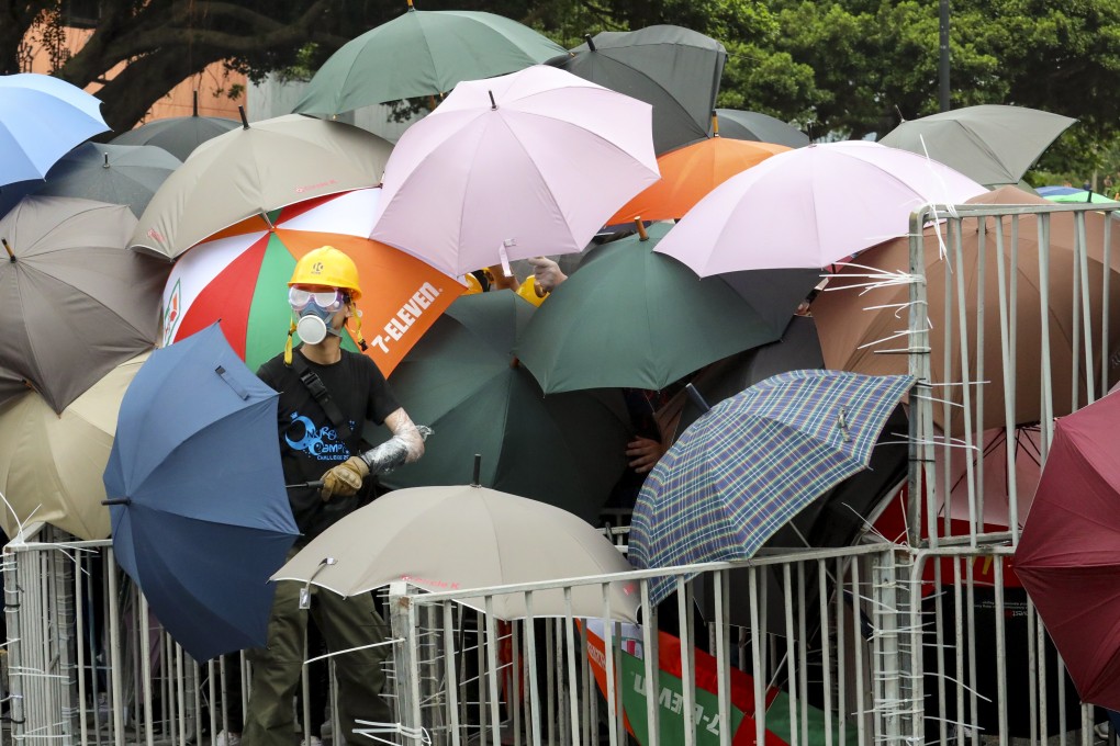 Protesters use umbrellas to protect themselves on Sunday as they face-off with riot police after a march in Sha Tin. Photo: Felix Wong