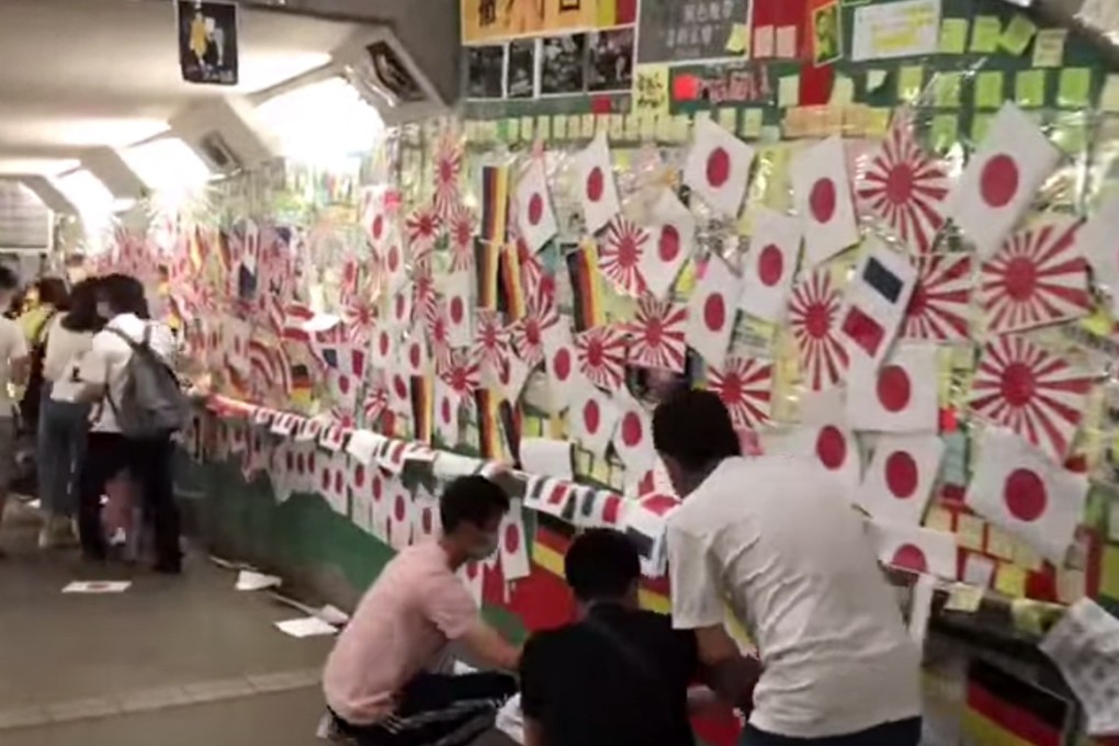Screen grab of a video showing a group of masked figures plastering flags of the Eight-Nation Alliance over the Lennon Wall in Tai Po. Photo: Facebook