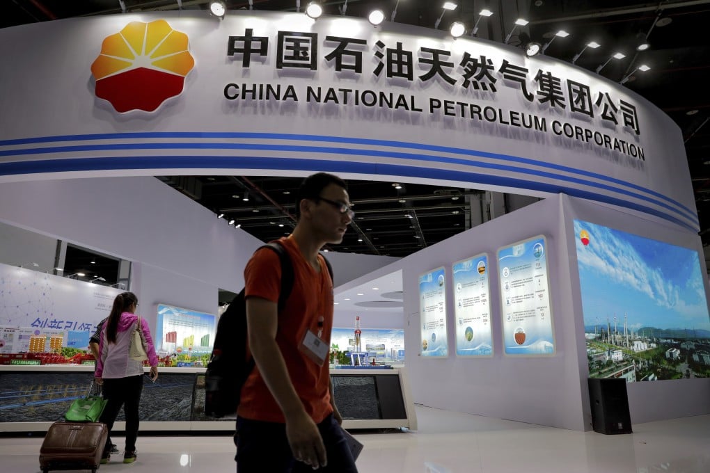 Visitors walk by an exhibition booth of China National Petroleum Corporation at an industry fair in Shanghai. Photo: AP