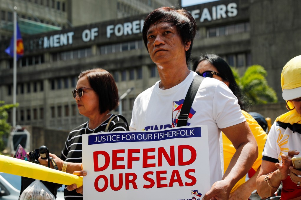 An activist protests against the alleged sinking of a Philippine fishing boat by a Chinese vessel at the Department of Foreign Affairs in Manila. Photo: EPA-EFE